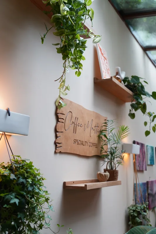 Coffee Matters sign framed by hanging plants